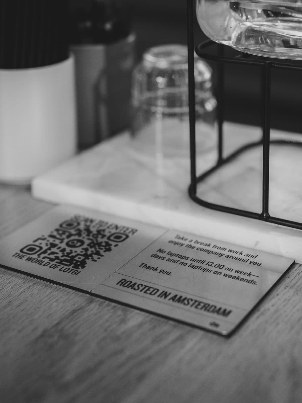 Printed QR code table tent on a cafe table, in black and white